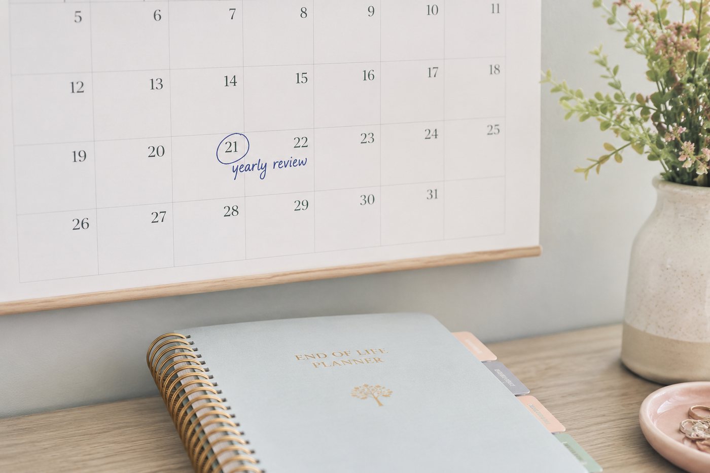 The End of Life Planner on a desk below a wall calendar marked yearly review.